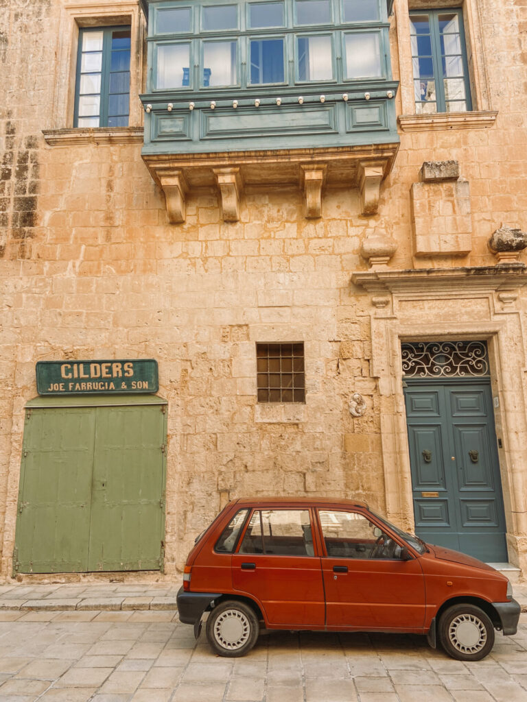 car in front of doors mdina malta